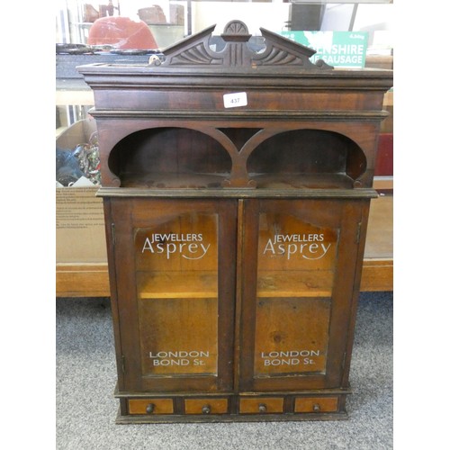 437 - A mahogany glazed cabinet, painted Aspreys Jewellers, London to each door, the cabinet has an open t... 