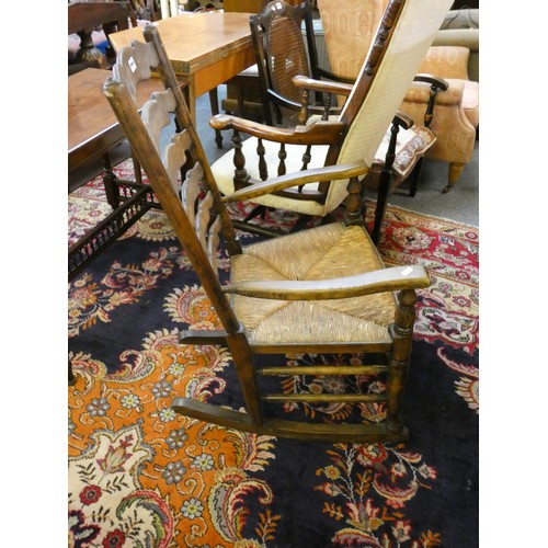 446 - A rush seated ladderback rocking chair and a Victorian upholstered mahogany armchair (2).