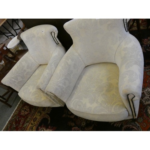 447 - A pair of tub armchairs, upholstered in white fabric with black studs (2).