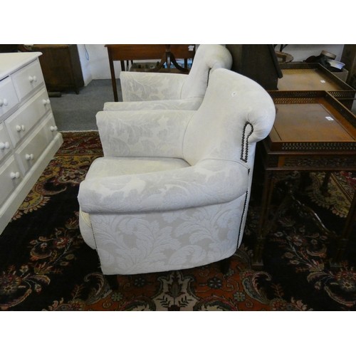 447 - A pair of tub armchairs, upholstered in white fabric with black studs (2).