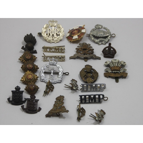 71 - A collection of cap badges and pips, to include the tank regiment, the Welch and HM Prisons