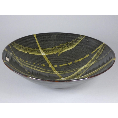 188 - Ron Green, a black glazed stoneware bowl with white detail, diameter 26 cm, together with a dark gre... 