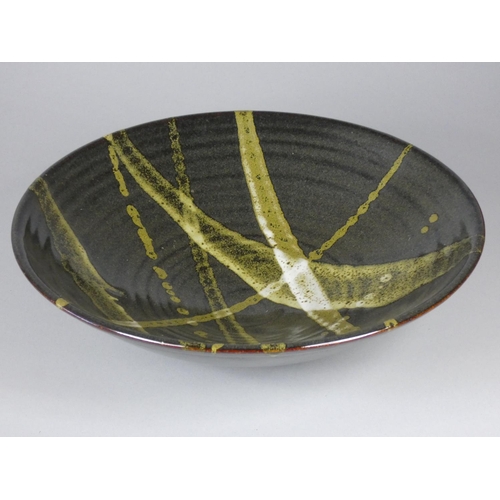 188 - Ron Green, a black glazed stoneware bowl with white detail, diameter 26 cm, together with a dark gre... 