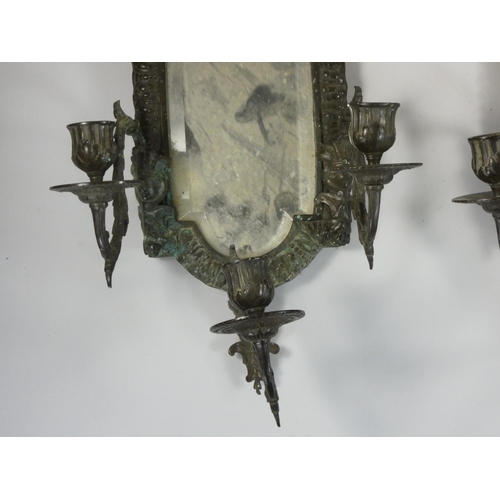 229 - A pair of bronzed metal wall sconces, with bevelled glass mirrors, the three scones with mask bases,... 