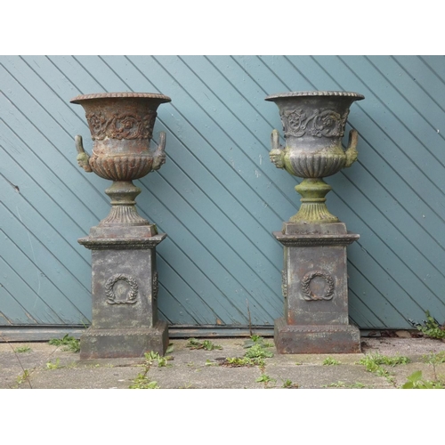 242 - A Victorian good quality pair of cast iron garden urns, twin handle with gadrooned borders and flora...
