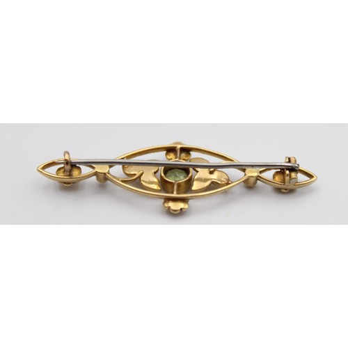 67 - An Edwardian gold, peridot and half pearl bar brooch, set with a mixed cut stone, 45mm, 3 gms.