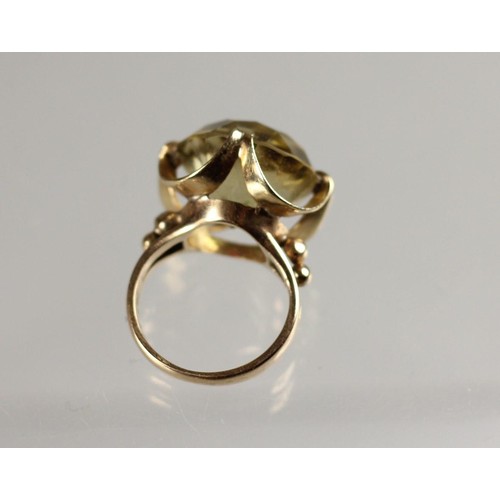 81 - An 18K pale citrine dress ring, claw set with a brilliant cut stone, diameter 16 mm, size K, 7 gms.