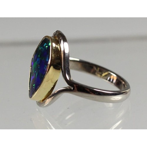 96 - An 18ct white gold Queensland black boulder opal and diamond ring, collet set with an irregular shap... 