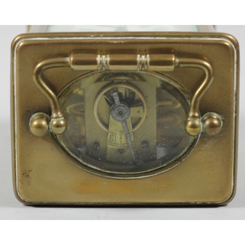 257 - A brass carriage time piece, the white enamel dial unsigned, height with handle raised 14 cm.