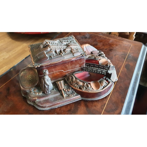 416 - A Japanese metal musical box/smokers companion, in the form of a pagoda cigarette box and an ashtray... 