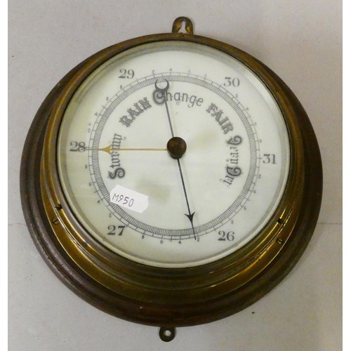 84 - A circular brass cased barometer mounted on hardwood base.
