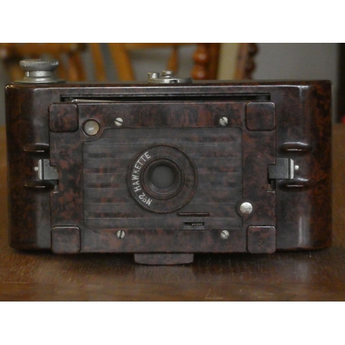 100 - A boxed Chinon 8mm projector, a Kodak Bakelite folding camera, free standing flash light and accesso... 