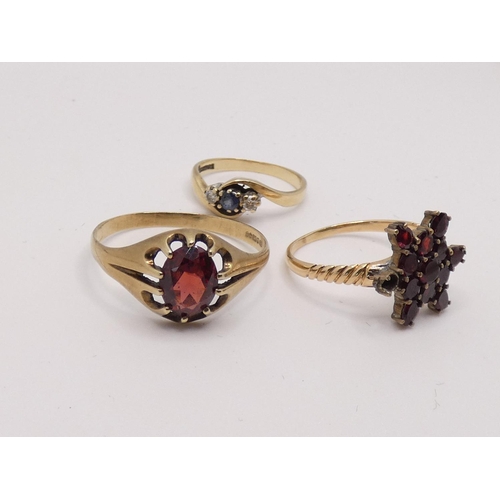 181 - A 9ct gold sapphire and diamond three stone ring, a 9ct gold garnet cluster ring and a 9ct gold sing... 