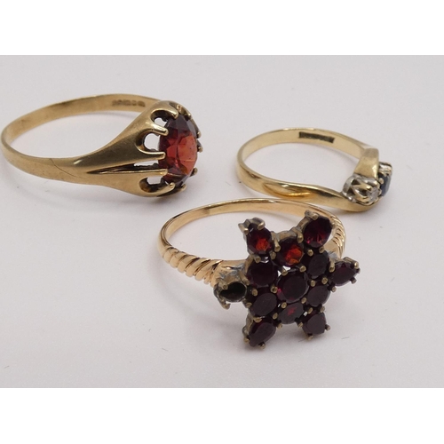 181 - A 9ct gold sapphire and diamond three stone ring, a 9ct gold garnet cluster ring and a 9ct gold sing... 