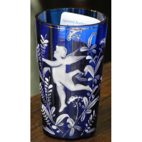 110 - A cobalt blue glass jug with white cherub decoration together with a matching drinking glass