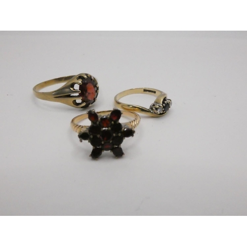 181 - A 9ct gold sapphire and diamond three stone ring, a 9ct gold garnet cluster ring and a 9ct gold sing... 
