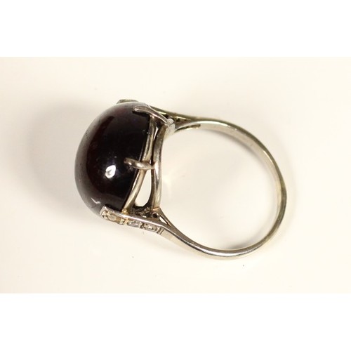 103 - A white gold and cabochon garnet dress ring, unmarked, probably 14K, diameter 13mm, diamond set shou... 