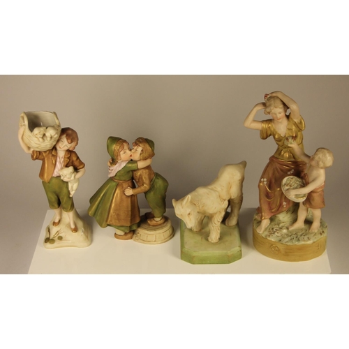 179 - Four Royal Dux figures to include, a lamb, a boy holding a basket of puppies, a couple kissing and a... 