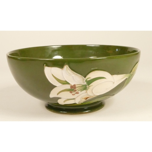 187 - A Moorcroft green glazed bowl with white lily, signed signature to base, 7 x 16 cm