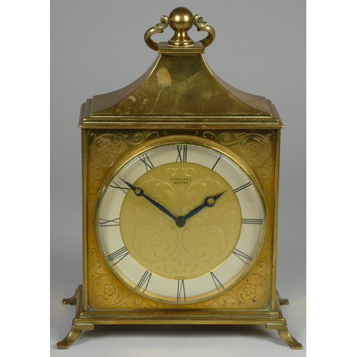 221 - A Junghans Meister brass mantle clock, decorated with a floral design, the silver chapter ring with ... 