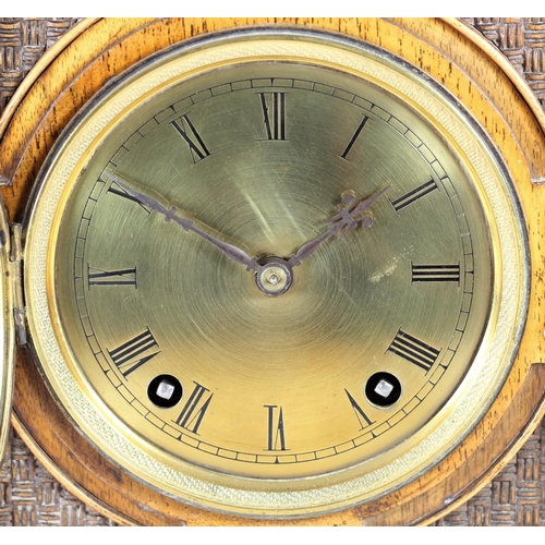 228 - An Arts and Crafts mantle clock, brass dial with Roman numerals, the case with carved decoration, th... 