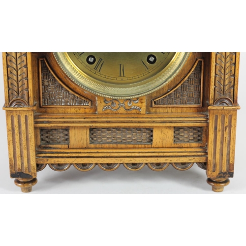 228 - An Arts and Crafts mantle clock, brass dial with Roman numerals, the case with carved decoration, th... 