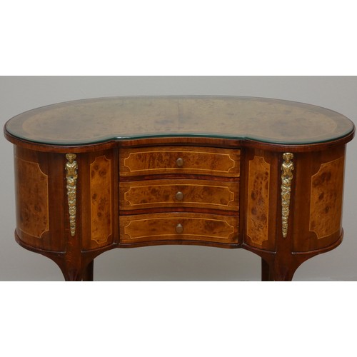 256 - A French kidney shape burr walnut and mahogany side table, with beaded edge, glass protector, over t... 