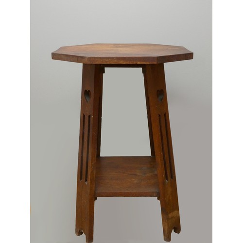 251 - An Art Nouveau Liberty style octagonal oak side table, raised on four heart pierced tapered legs.
71... 