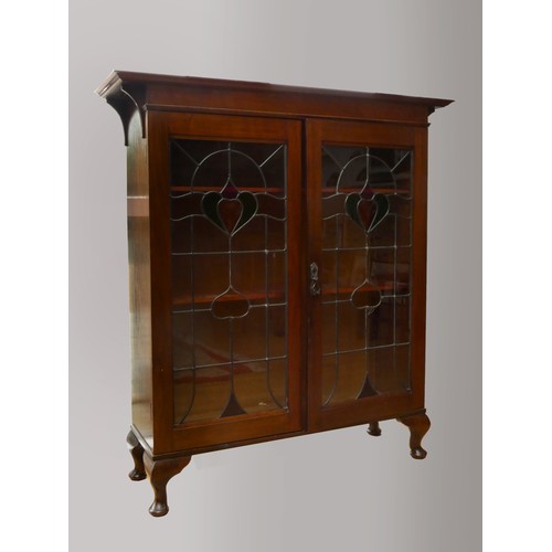 254 - An English Art Nouveau mahogany display cabinet, with original leaded coloured glass doors, interior... 