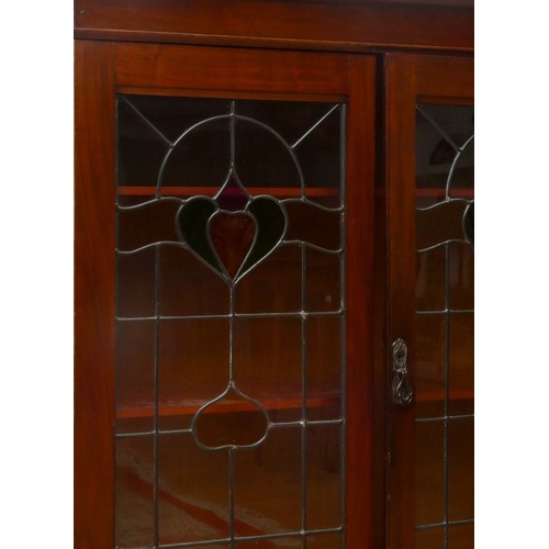 254 - An English Art Nouveau mahogany display cabinet, with original leaded coloured glass doors, interior... 