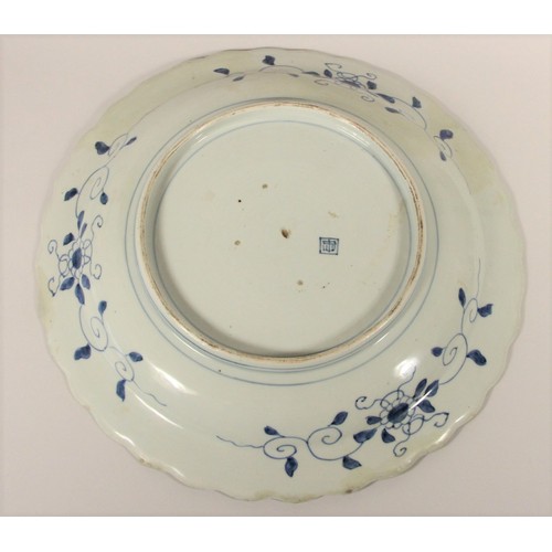 199 - A Kang Si blue and white charger, with central bird and foliage design, floral wavy boarder, charact... 