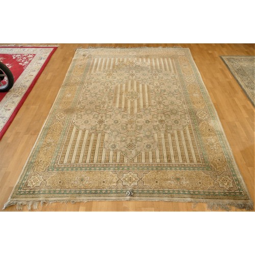 261 - A signed antique Persian rug, the pale gold and green geometric pattern field with outer border, sig... 