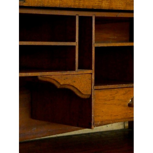 239 - An Edwardian oak roll-top pedestal desk, the tambour top opening to reveal a fitted interior, four d... 