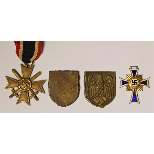 258 - WWII German Mother Cross in gold, Merit Cross with swords and tow Pith helmet badges