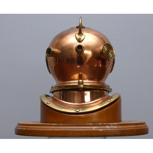 401 - A brass and copper novelty quartz desk clock, in the form of a divers helmet, wooden plinth, 19cm.