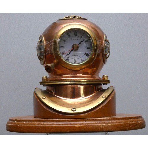 401 - A brass and copper novelty quartz desk clock, in the form of a divers helmet, wooden plinth, 19cm.