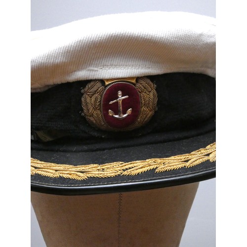 420 - A Mercantile Marine officers overcoat, with cap, braid and spare buttons, 48cm across the shoulders