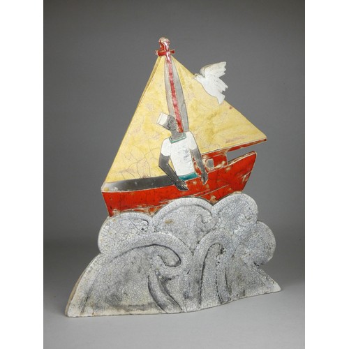 419 - Sarah Noel, a slab side and raku nautical figure of a sailor in a red sail boat, signed, 32cm