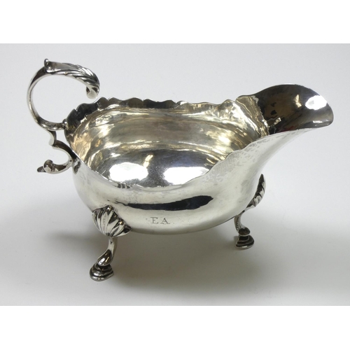 66 - A George III silver sauce boat, makers mark poorly struck, London 1772, with wavy edge and leaf capp... 