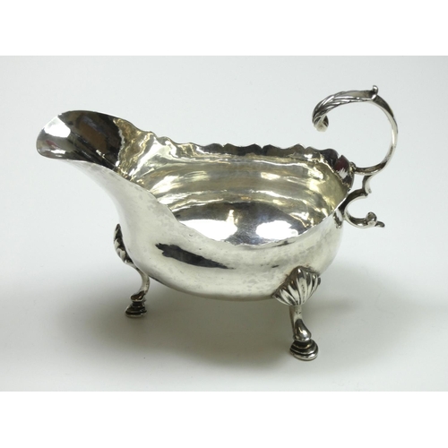 66 - A George III silver sauce boat, makers mark poorly struck, London 1772, with wavy edge and leaf capp... 