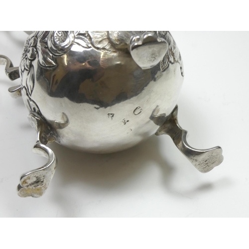 67 - A George II/III silver baluster cream jug, marks worn, with embossed and chased decoration, leaf cap... 