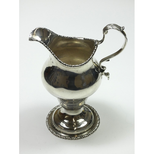 68 - A George III silver baluster cream jug, marks worn, London 1778, with gadrooned border, leaf capped ... 