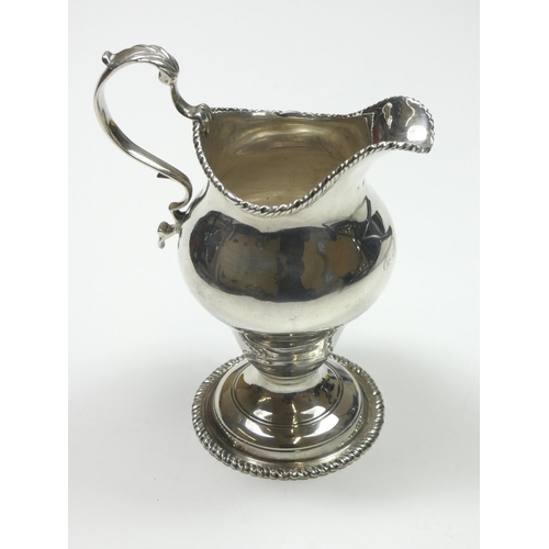 68 - A George III silver baluster cream jug, marks worn, London 1778, with gadrooned border, leaf capped ... 