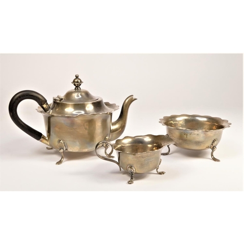 74 - An Edwardian silver three piece tea service, Birmingham 1902, of circular form with wavy border, rai... 