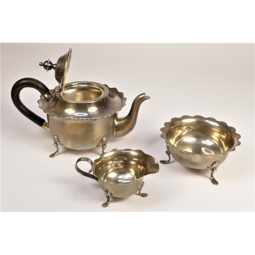 74 - An Edwardian silver three piece tea service, Birmingham 1902, of circular form with wavy border, rai... 