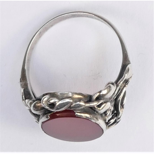 129 - An Arts & Craft cornelian and silver ring, with floral surround, size M