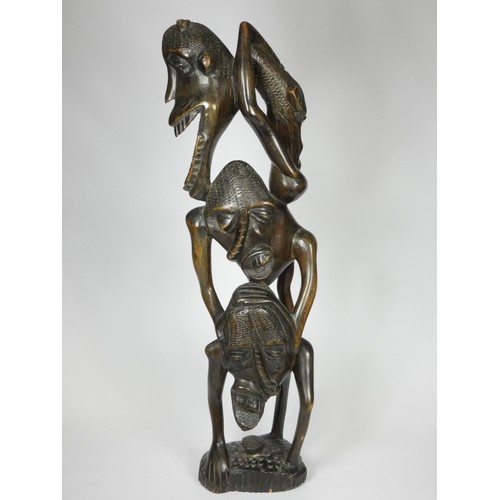 209 - A Makonde Ujamaa blackwood sculpture, depicting human figures climbing up and holding onto each othe... 