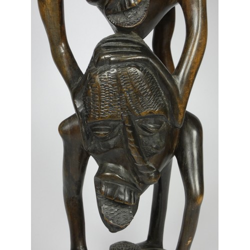 209 - A Makonde Ujamaa blackwood sculpture, depicting human figures climbing up and holding onto each othe... 