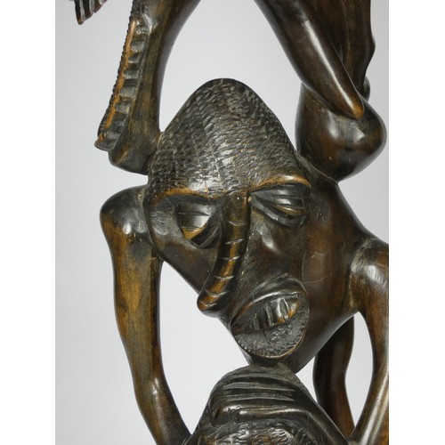 209 - A Makonde Ujamaa blackwood sculpture, depicting human figures climbing up and holding onto each othe... 