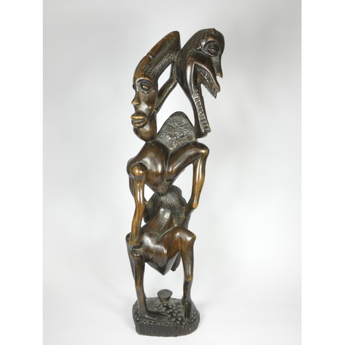 209 - A Makonde Ujamaa blackwood sculpture, depicting human figures climbing up and holding onto each othe... 